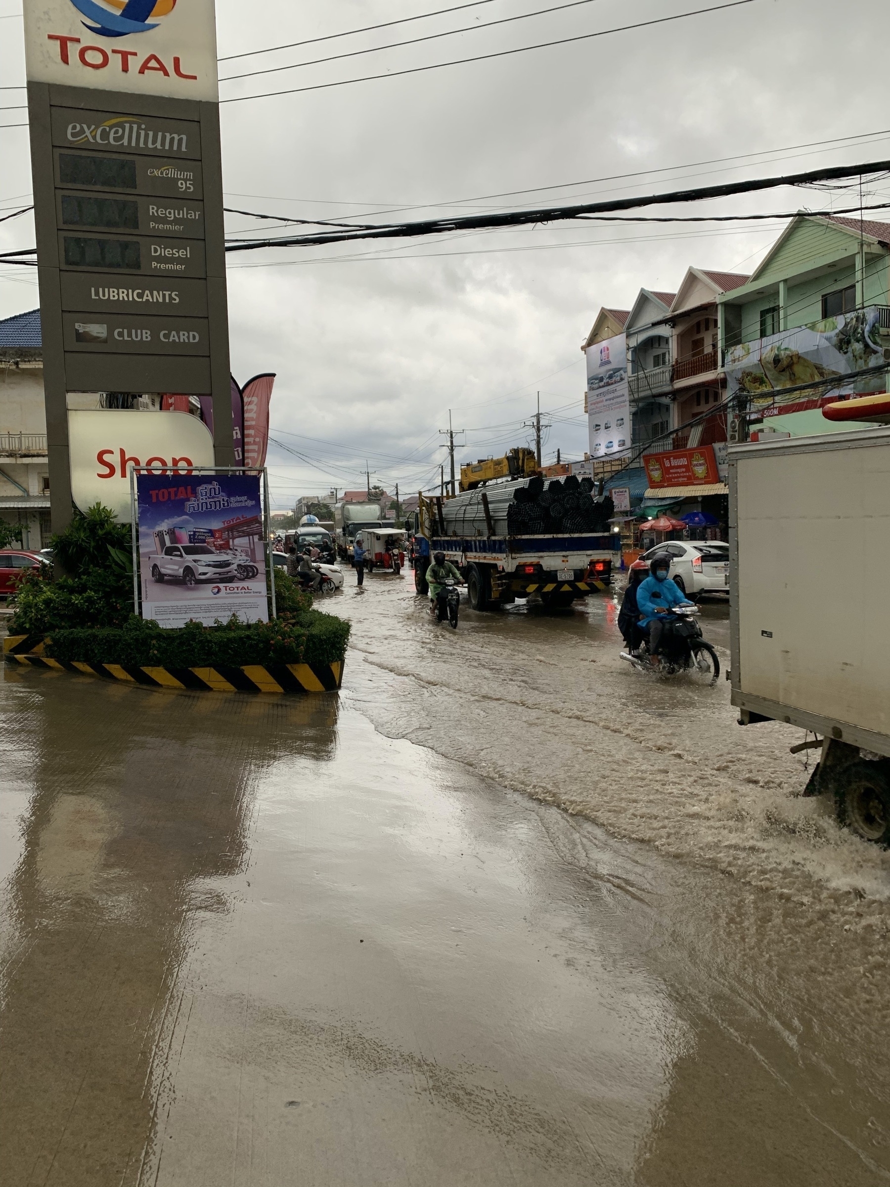 Shin deep policeman directing traffic through flooded intersection